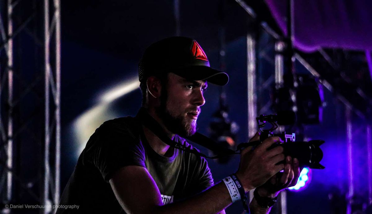 Niek met een camera op een gimbal in paars podiumlicht