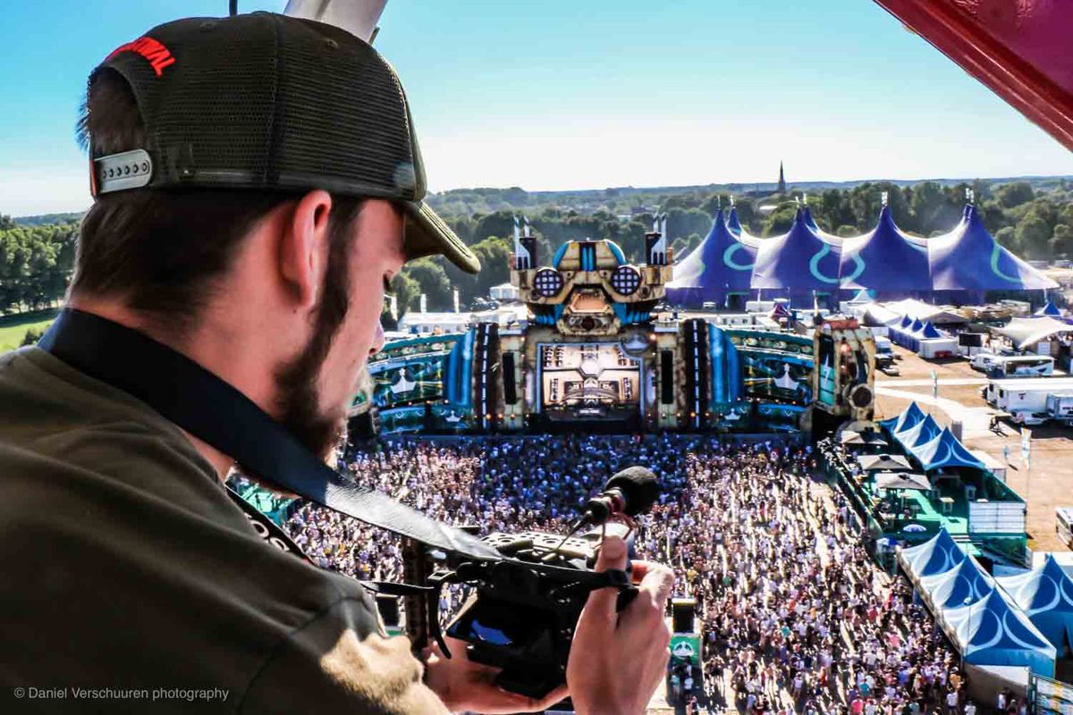 Niek met camera op een festival, uitkijkend over de mainstage en het publiek